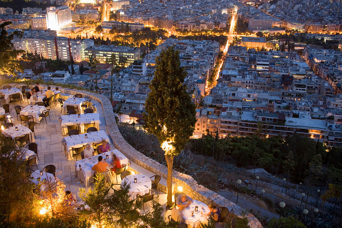 View from the Lykavittos Hill over a restaurant to the ocean of houses of the town at night, Athens, Athens-Piraeus, Greece