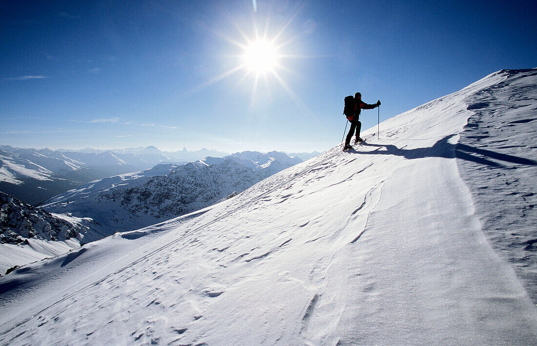 Men hikes with touringskis to a summit. Parsenn, Davos, Graubuenden, Grisons, Switzerland, Alps Europe, MR