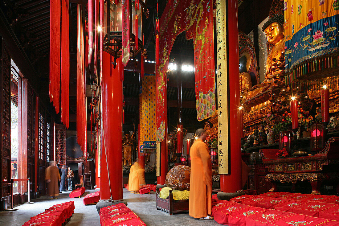 Jade Buddha Temple,Jade Buddha Temple, Andacht in der Haupthalle, Tempelanlage aus der Song Dynastie, Mittelpunkt eine Buddha-Statue aus Jade, several halls, Grand Hall, rote Säulen und Gebetsfahnen, red column and prayer flags, Mönch in orange, monk pray