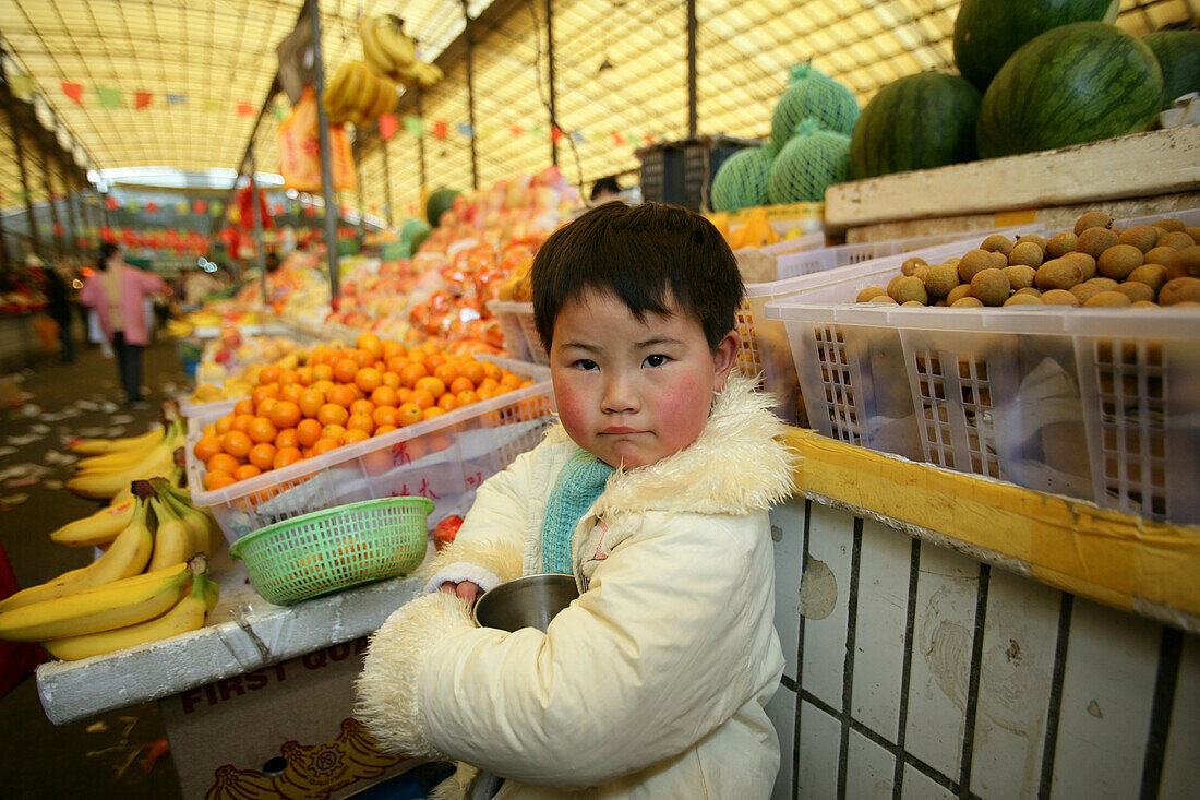 kid, child,young boy at the market stand of his parents, market hall, fruit and vegetables, Little Emperor