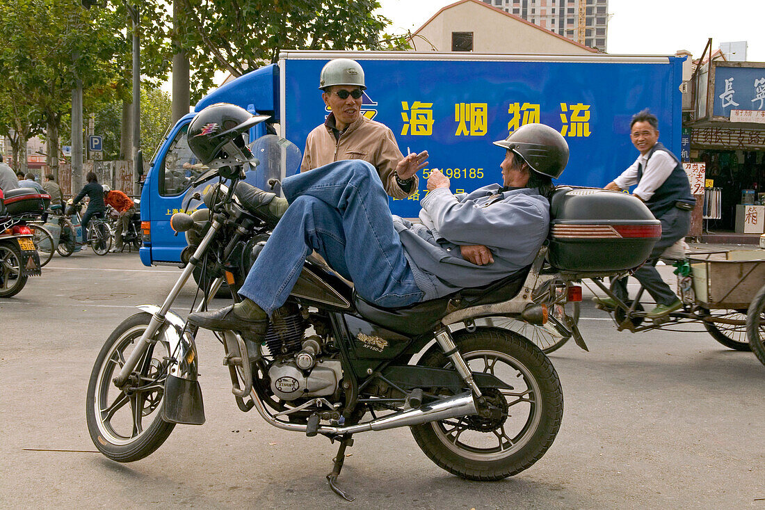 Traffic Shanghai,motorbike taxi, driver, courier, Motorradkurier, Motorradtaxi, relaxed, Pause, Mittagspause, lunch break, helmet, Helm, entspannt, Strassenkreuzung, street junction, aus: "Mythos Shanghai", Shanghai, Sachbuch, Bildband, Fotos Karl Johaent