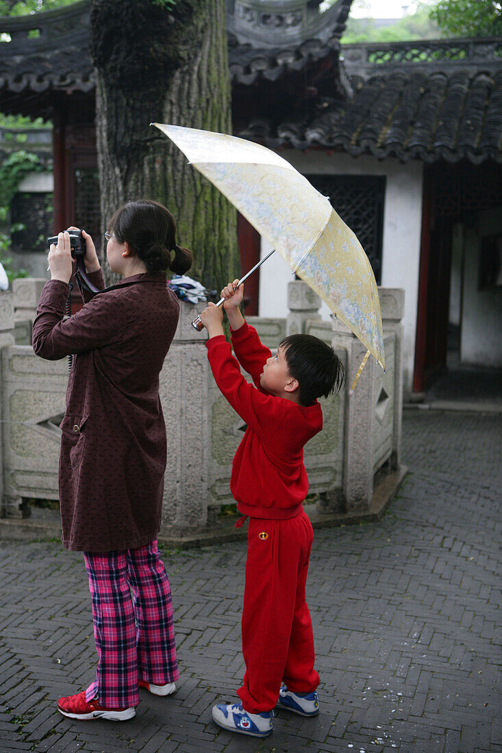 visitors taking photo in rain, umbrella, Yu Yuan Garden, Shanghai