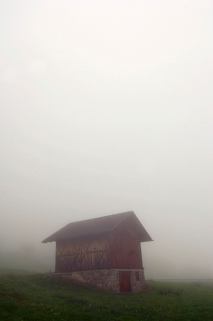 Lonesome alpine hut in the fog, South Tyrol, Italy