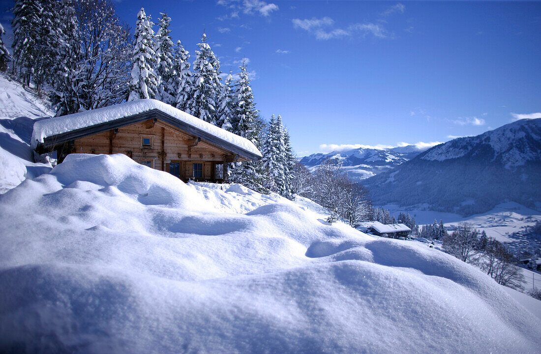 Snow covered log cabin, holiday ski lodge, Nieding, Brixen im Thale, Alps, Tyrol, Austria
