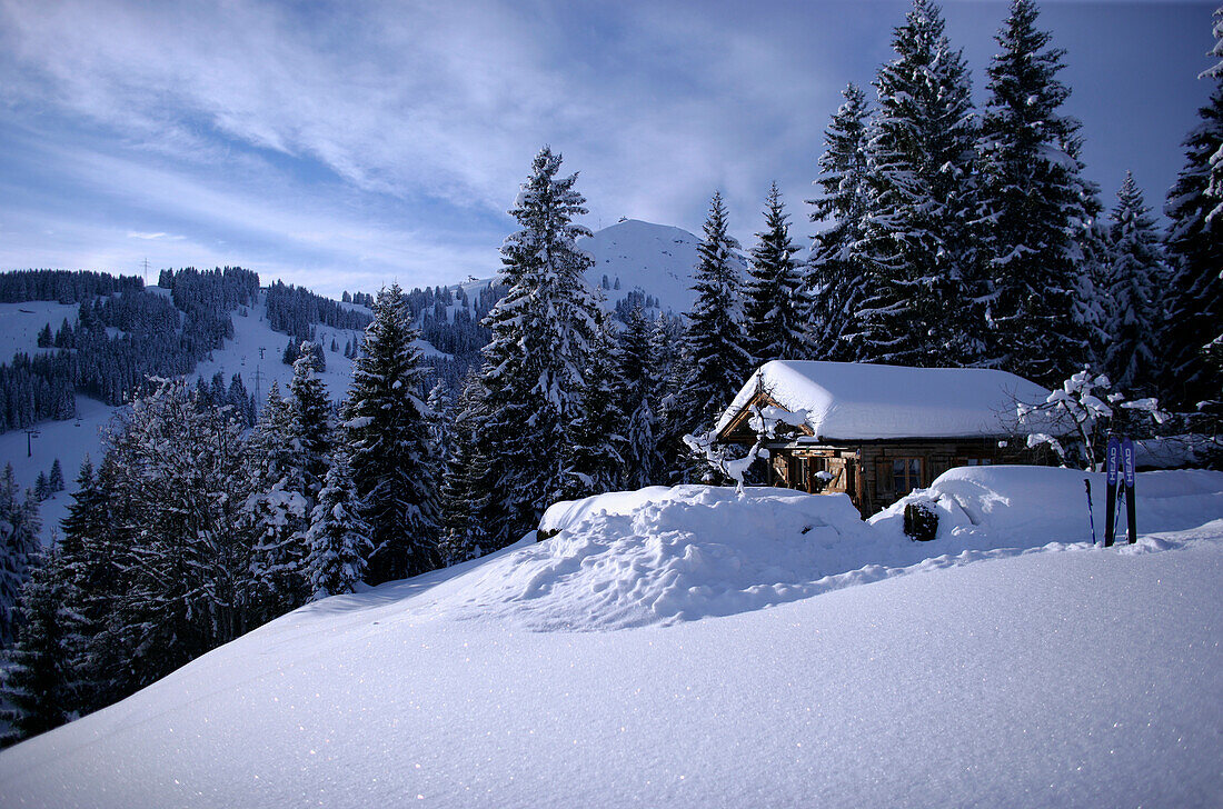 Alpine ski hut and skis in the snow, with the Hohe Salve in the background, Brixen im Thale, Alps Tyrol, Austria