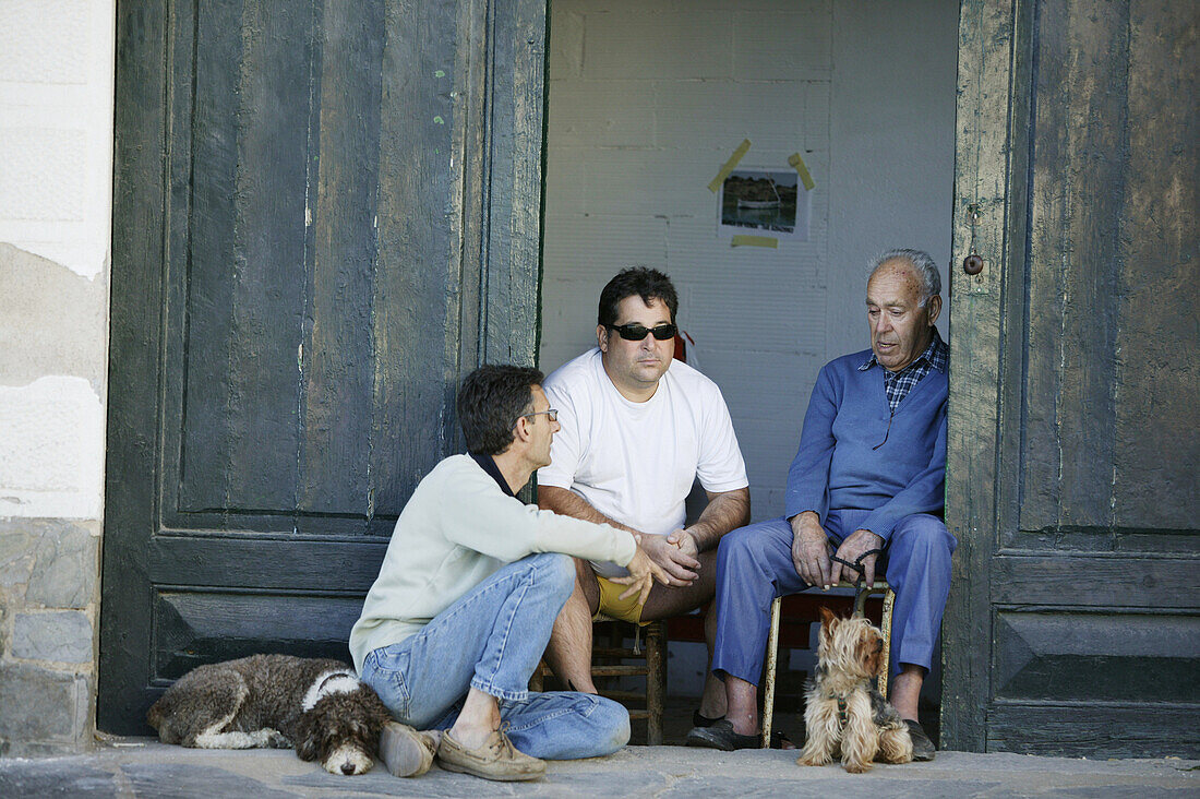 Costa Brava,Männer mit Hunden vor Hauseingang Cadaques,Costa Brava, Katalonien Spanien