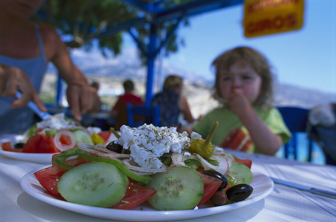 People eating greek salad in restaurant, Karpathos, Dodecanese Islands, Greece