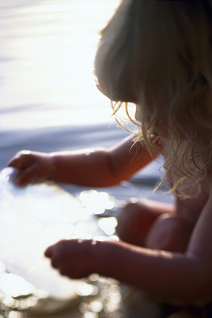 Little girl looking into plastic bowl