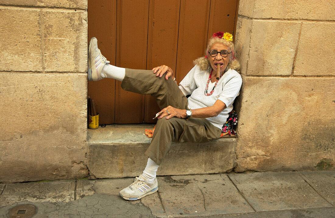 Alte Kubanerin sitz vor einer Tür und raucht Zigarre, La Bodeguita del Medio, Havanna