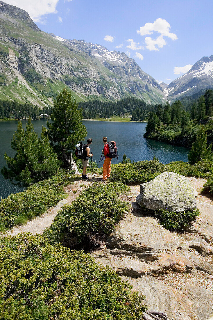 Zwei wandernde Frauen rasten vor Bergsee. Lägh Cavloc, Cavloc See, Forno, Bergell, Graubünden, Graubuenden, Schweiz, Alpen.