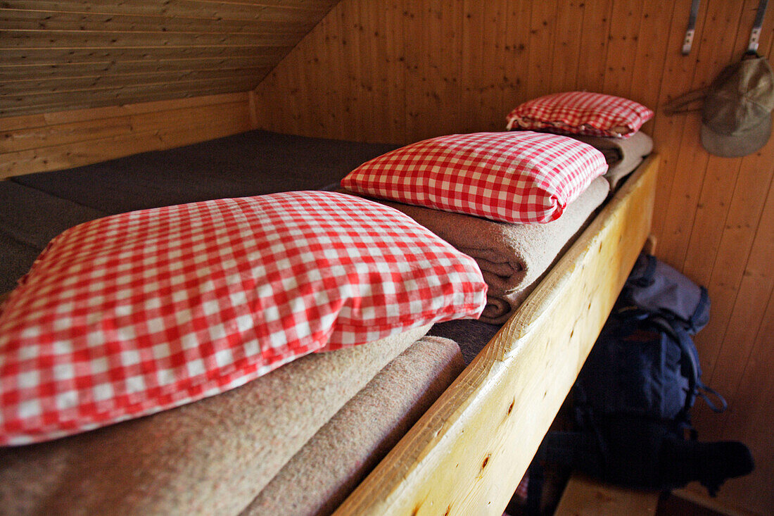 Kissen und Wolldecken in einer Berghütte. Forno Hütte, SAC, Bergell, Graubünden, Graubuenden, Schweiz, Alpen.