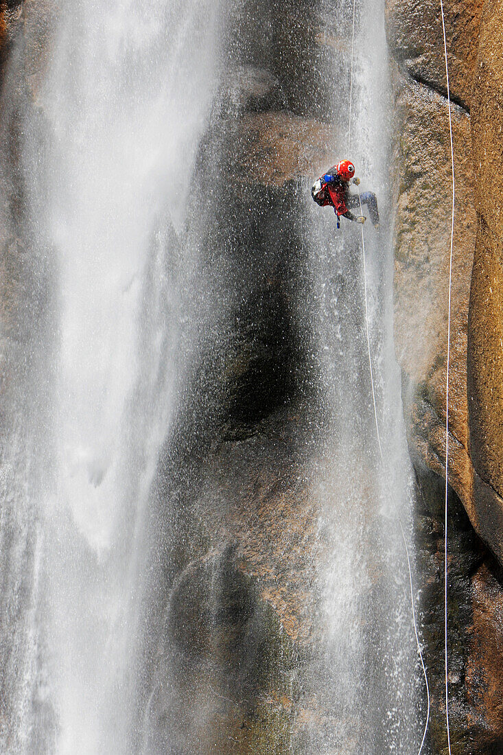 Canyoning, Ein Man seilt in einem Wasserfall ab, Piscia di Gallu, Ospedale, Mittelmeer, Korsika, Frankreich
