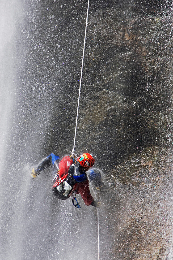 Canyoning, Ein Man seilt in einem Wasserfall ab, Piscia di Gallu, Ospedale, Mittelmeer, Korsika, Frankreich