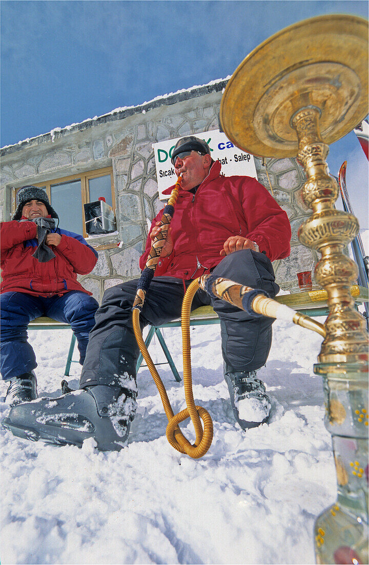 Zwei Männer rauchen die Wasserpfeife im Wintersportort Dorukaya, Bolu, Türkei