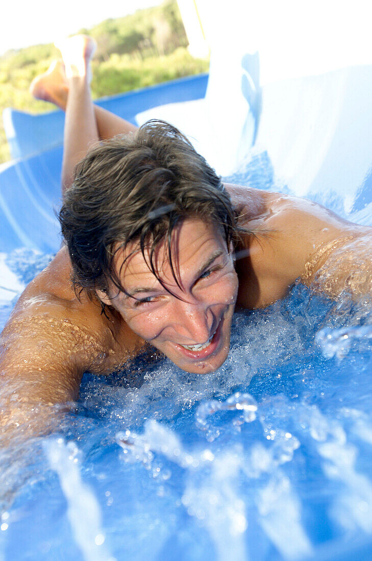 Lachender Mann in Wasserrutsche