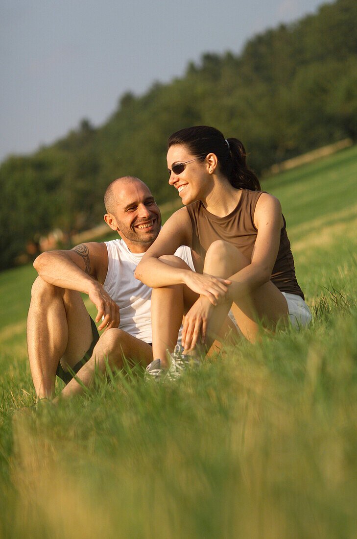 Lächelndes Paar sitzt im Gras