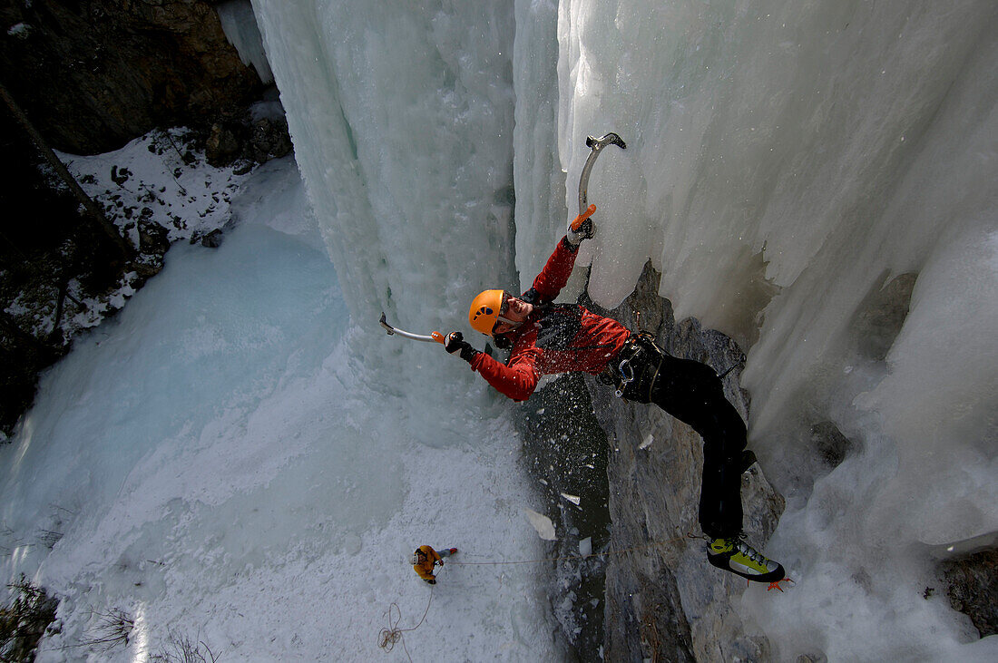 Male ice climber ascending ice, British Columbia, Canada