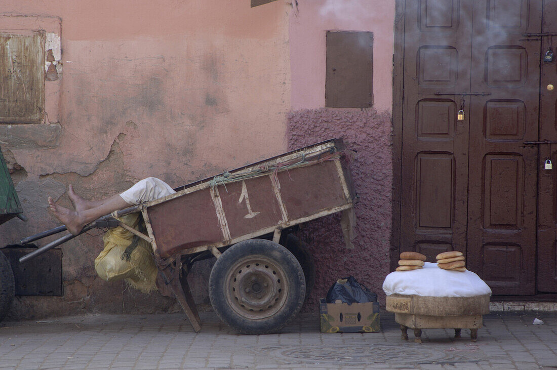 Store with dried fruits and nuts, man sleep in a wheelbarrow, Souks of Marrakech, Morocco