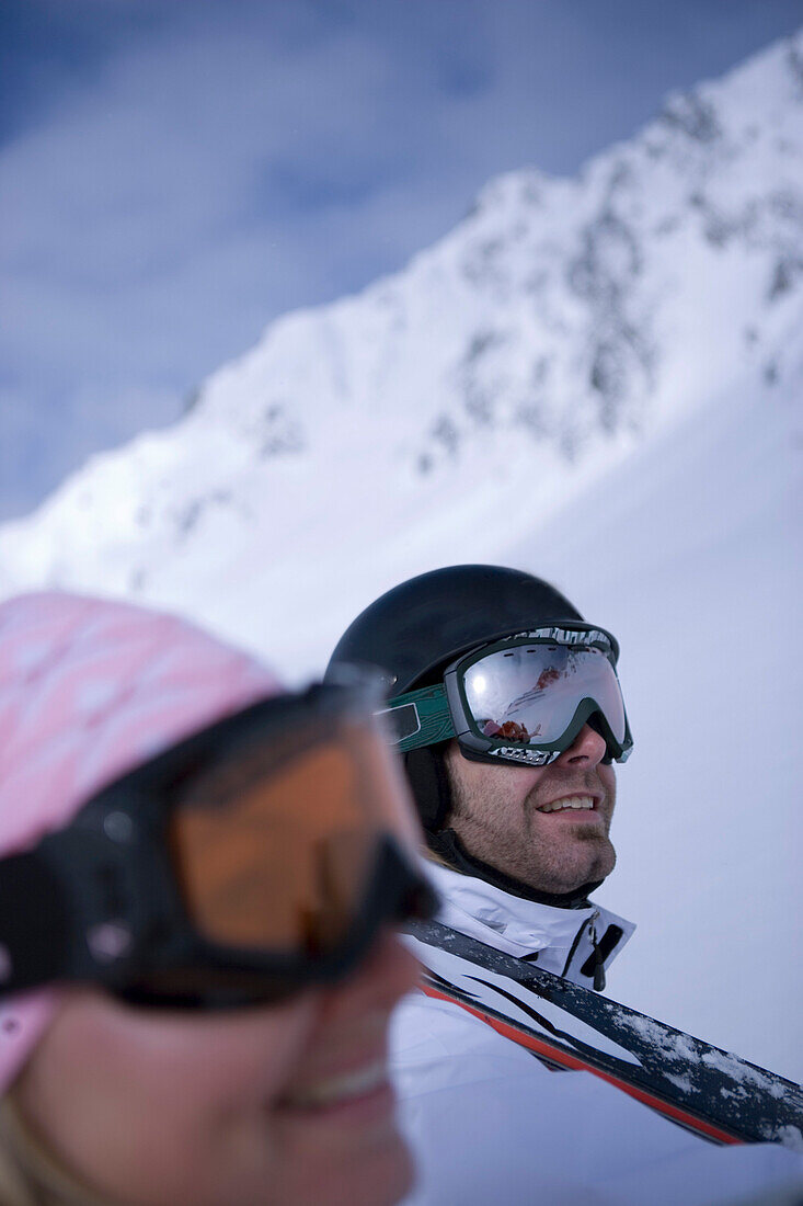 Junges Paar trägt Skier auf den Schultern, Kühtai, Tirol, Österreich
