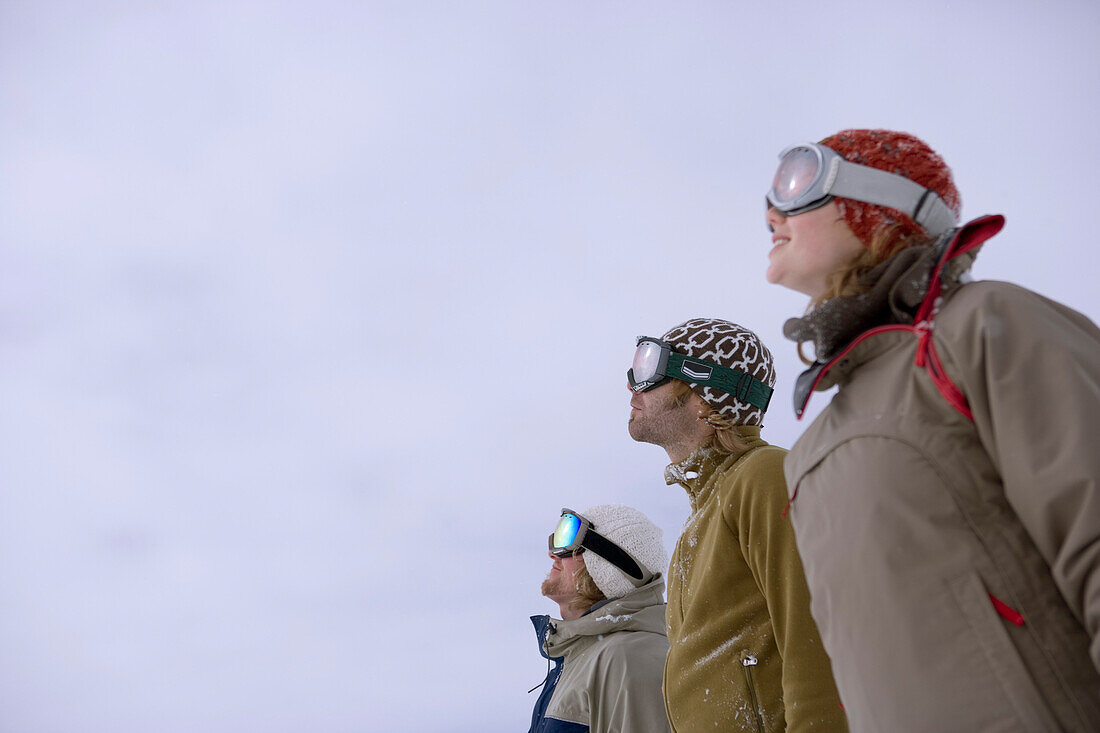 Gruppe junger Leute steht in einer Reihe an der Skipiste, Kühtai, Tirol, Österreich