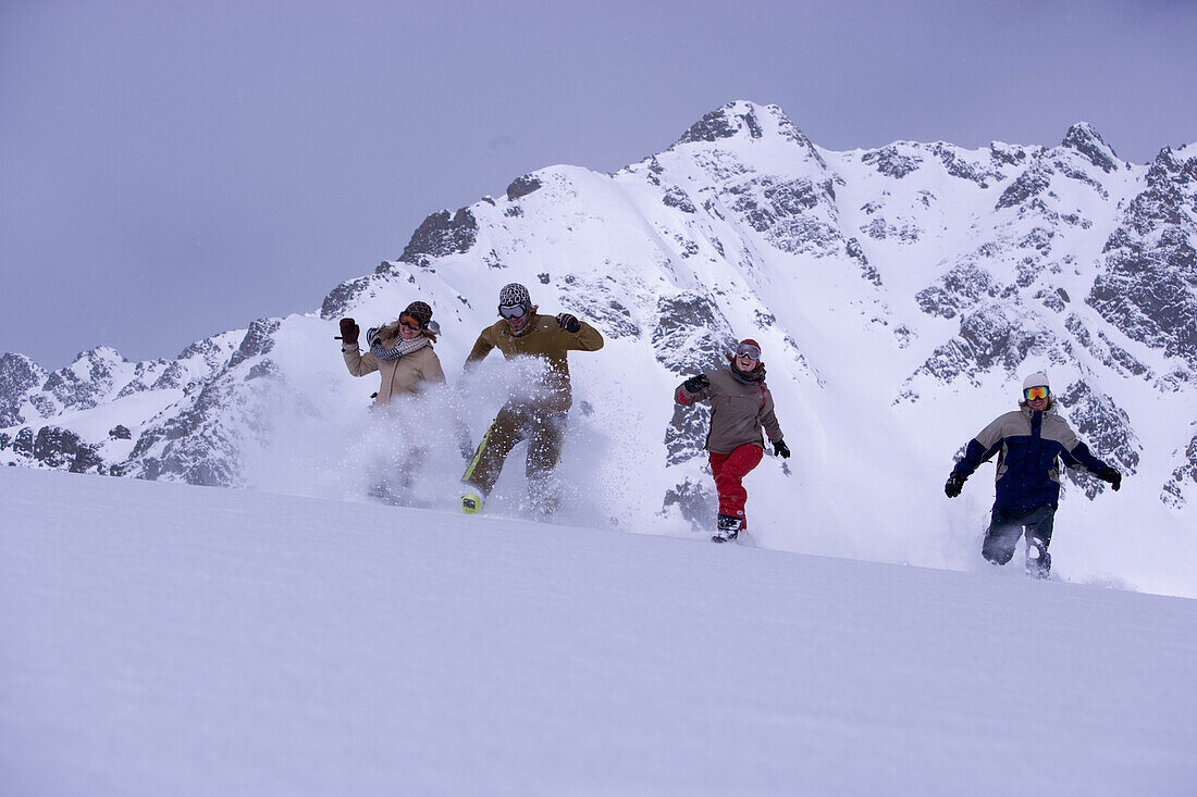 Vier Person laufen schneebedeckten Hang hinunter, Kühtai, Tirol, Österreich