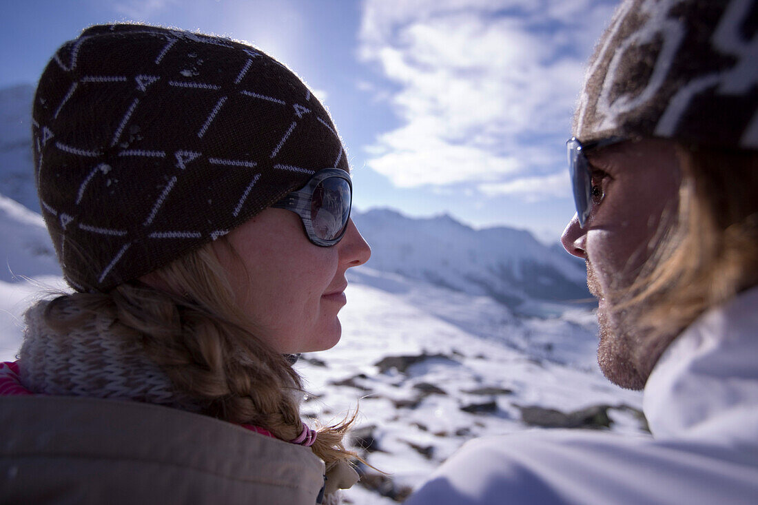 Junges Paar sitzt neben der Skipiste, Kühtai, Tirol, Österreich