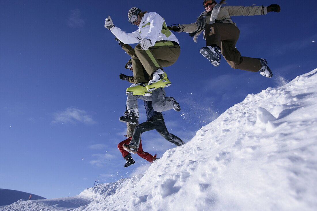Gruppe junger Personen springen im Schnee, Kühtai, Tirol, Österreich