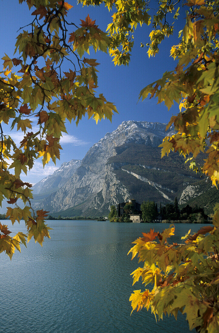 Lago Toblino mit Schloss und Berge, eingerahmt von Herbstlaub, Trentino, Italien