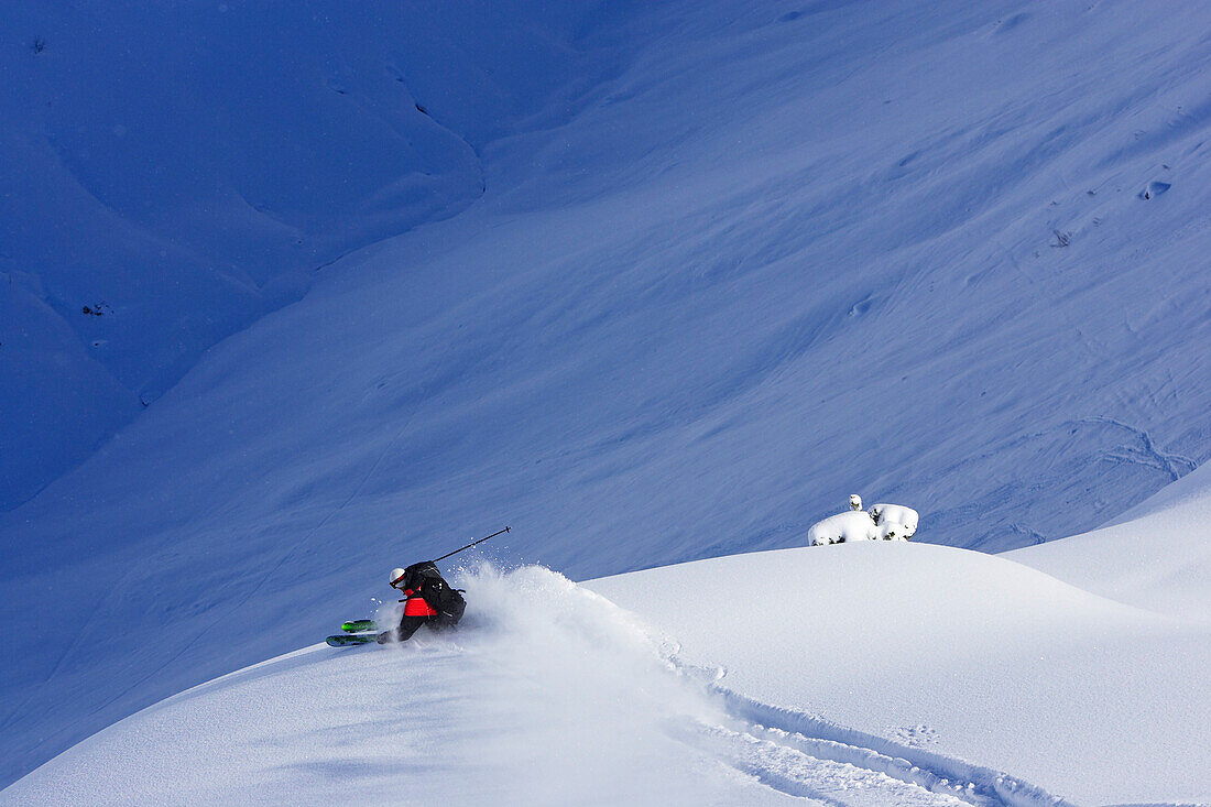 Ein Mann, ein Skifahrer kurvt durch einen unberührten Schneehang. Lech, Zürs, Arlberg, Österreich, Alpen, Europa, MR