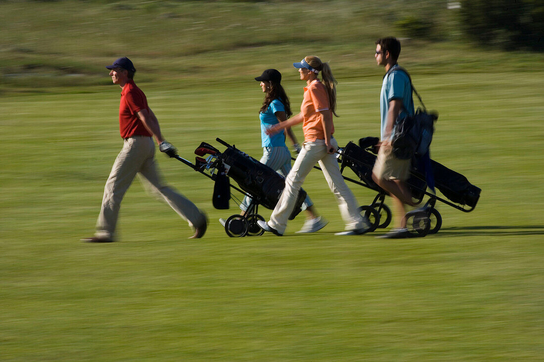 Gruppe von Golfspielern ziehen Golftaschen, Apulien, Italien