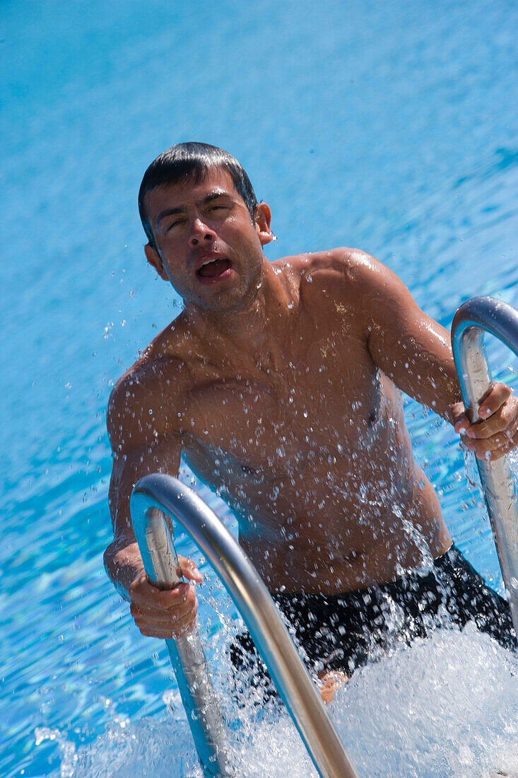 Young man going out of swimming pool, Apulia, Italy