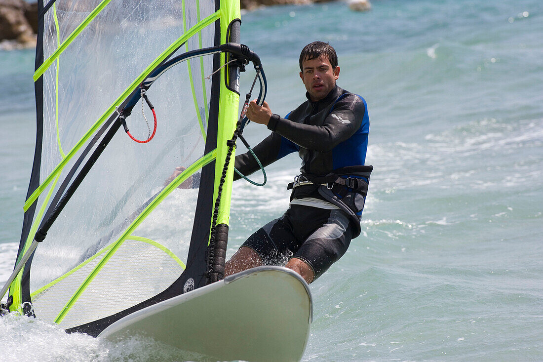 Young man windsurfing, Apulia, Italy