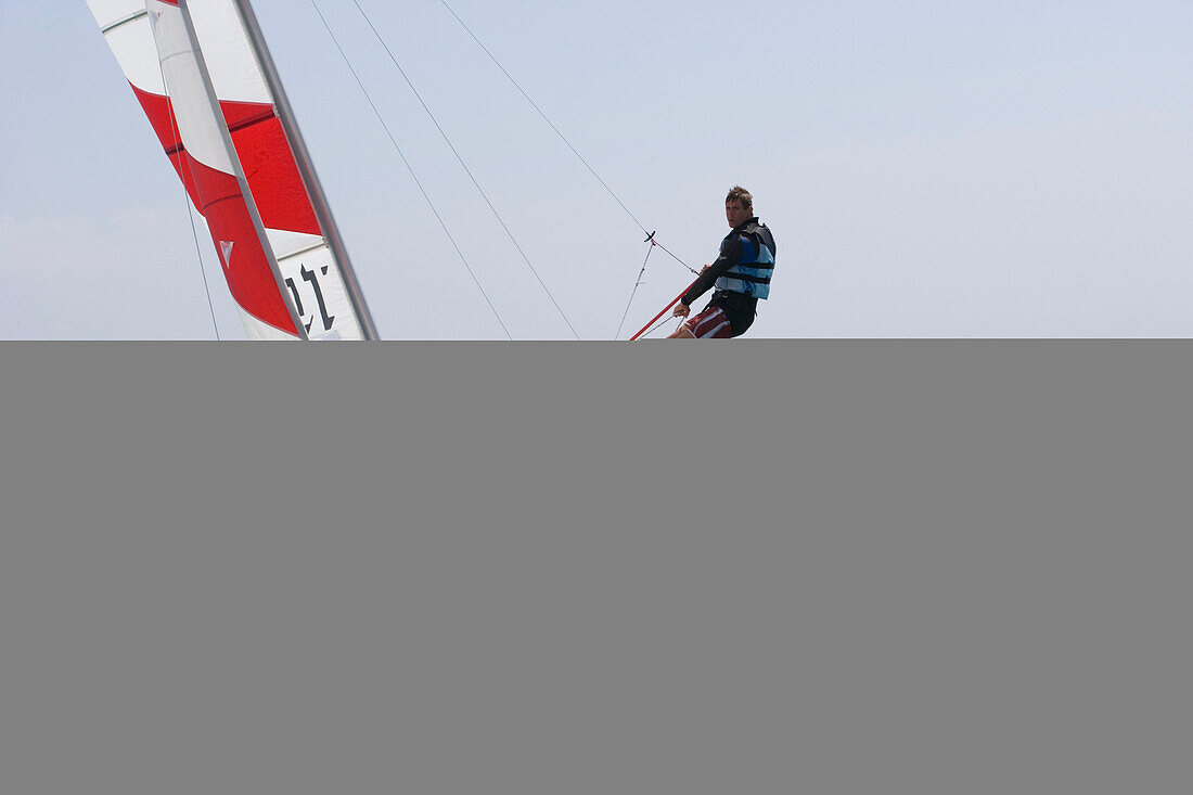 Mann segelt mit Kathamaran, Apulien, Italien