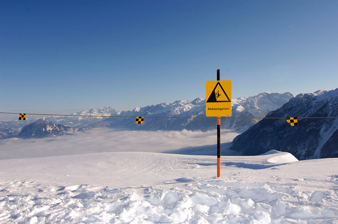 Ein Warnschild im Schnee unter blauem Himmel, Berchtesgardener Land, Bayern, Deutschland