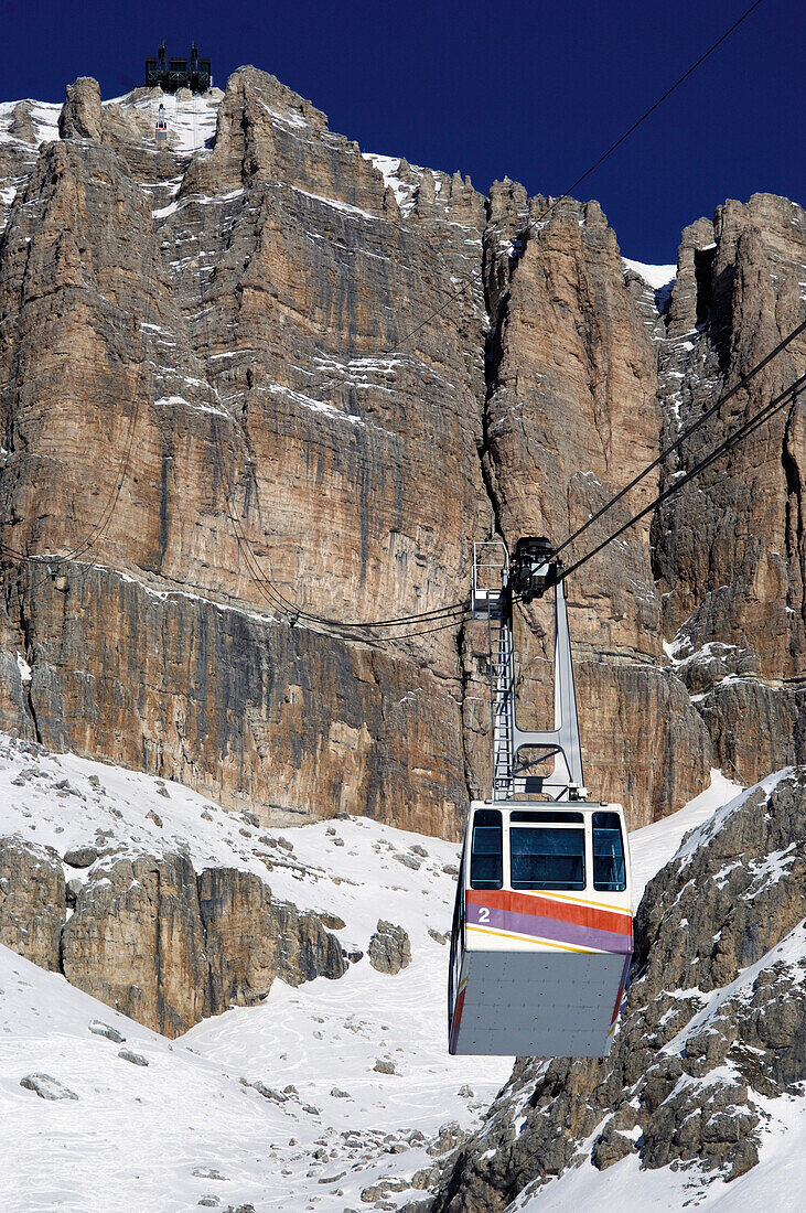 Overhead cable car in snowcovered  mountains, Passo Pordoi, Dolomites, Italy