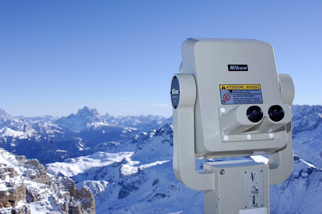 Coin-operated binoculars in front of snow covered landscape, Passo Pordoi, Dolomites, Italy, Europe