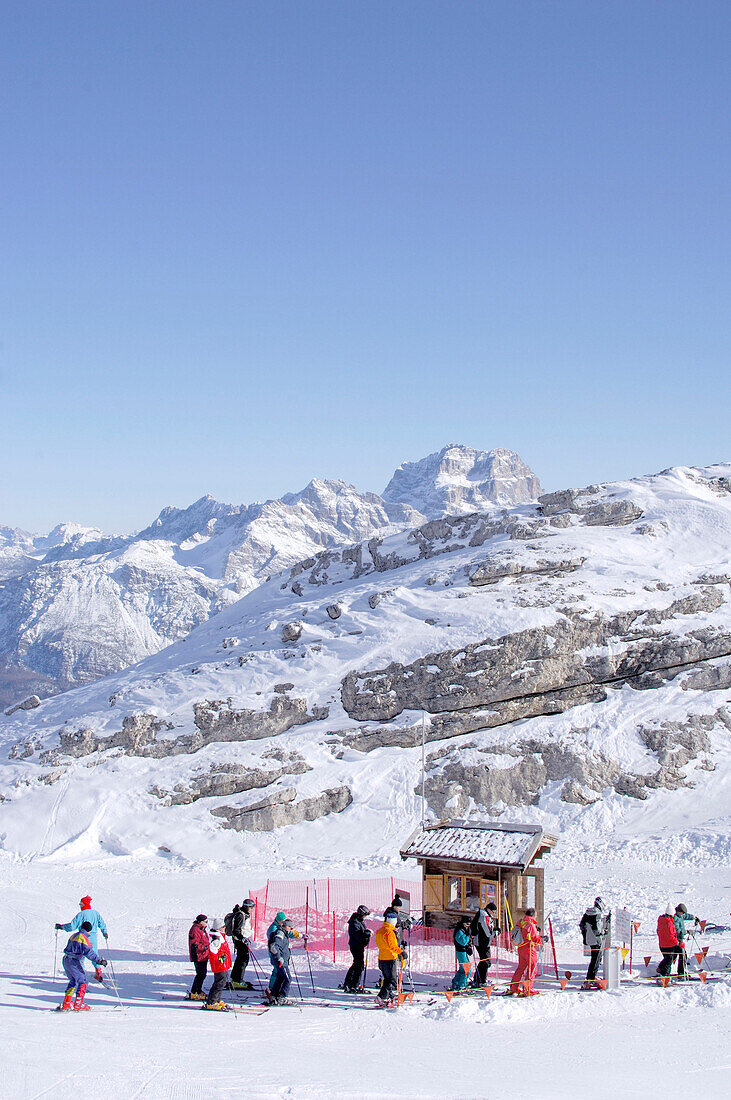 Skifahrer am Skilift vor schneebedeckten Bergen, Gruppo della Marmolata, Dolomiten, Italien, Europa