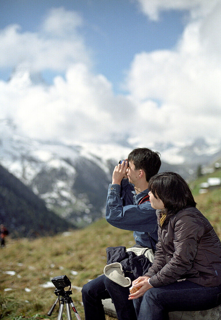 Japanese tourists photographing mountains, Zermatt, Switzerland