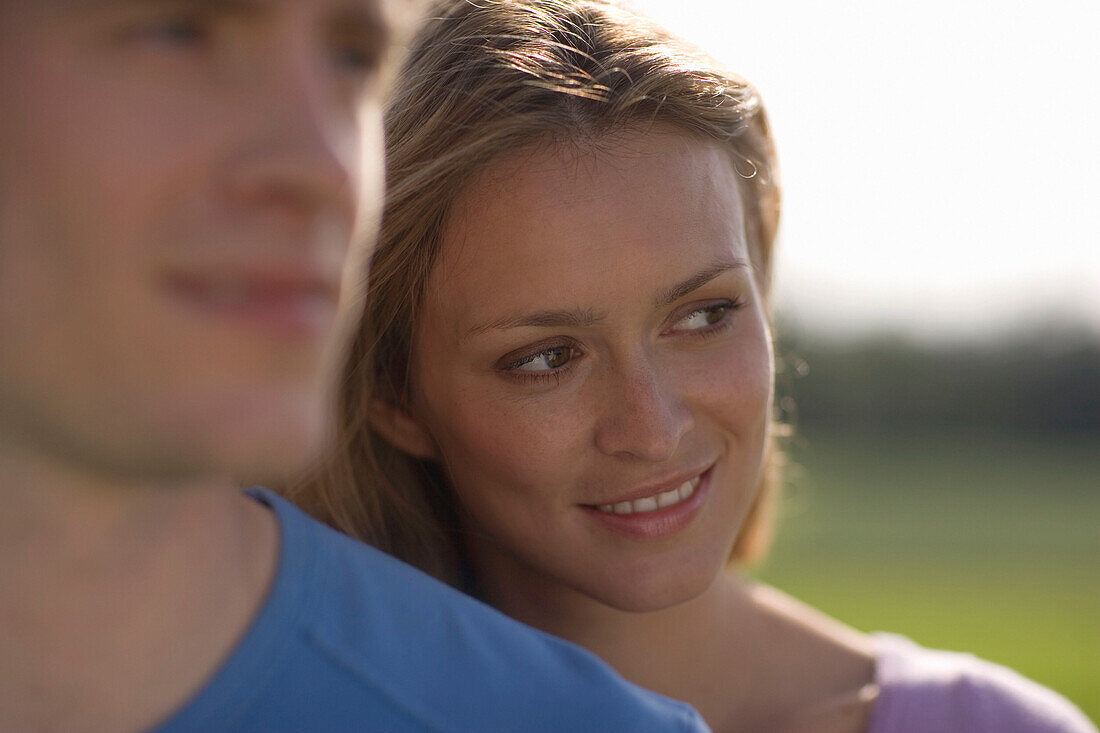 Young couple in nature, woman behind man