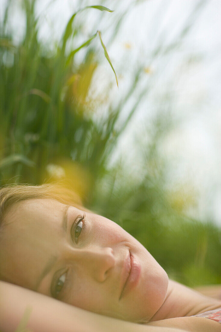 Junge Frau liegt auf einer Wiese, close-up