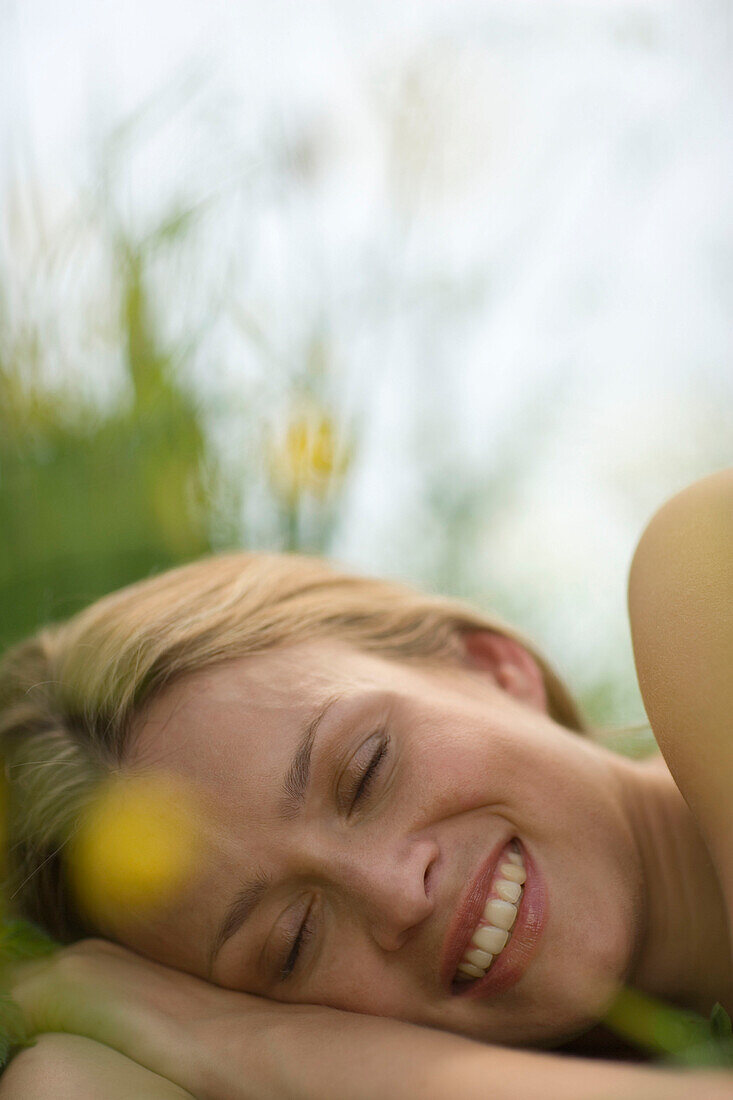 Young woman lying on meadow, close-up