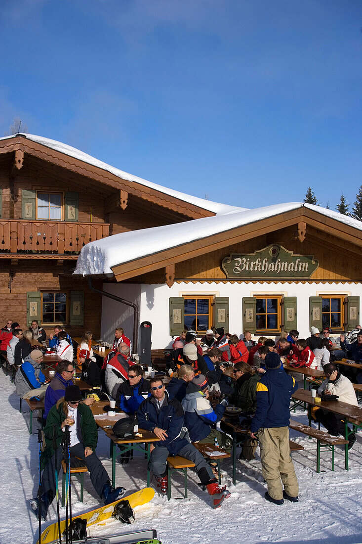 Skiers sitting in front of mountain restaurant (Birkhahnalm), Flachau, Salzburger Land, Austria