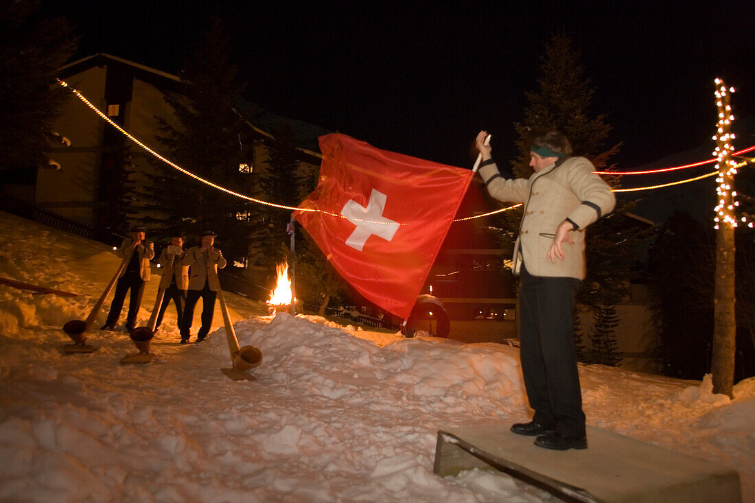 A flagswinger and swiss horn players at night, Saas-Fee, Valais, Switzerland