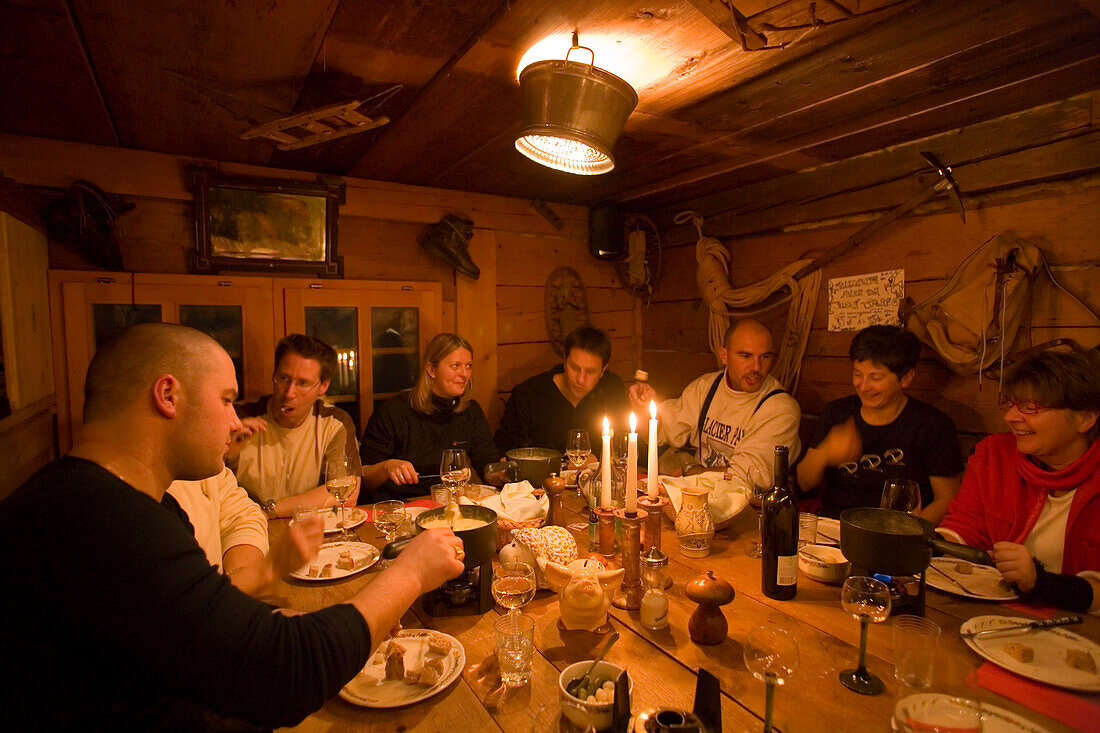People having a cheese fondue, Fondue Hut of the Restaurant and Hotel Hohnegg, Saas-Fee, Valais, Switzerland