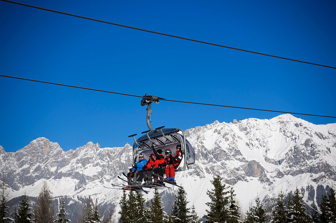 Skiers using the chair lift Hochwurzen Fun Jet, summit of the Dachsteinregion at horizon, Hochwurzen, Schladming, Ski Amade, Styria, Austria