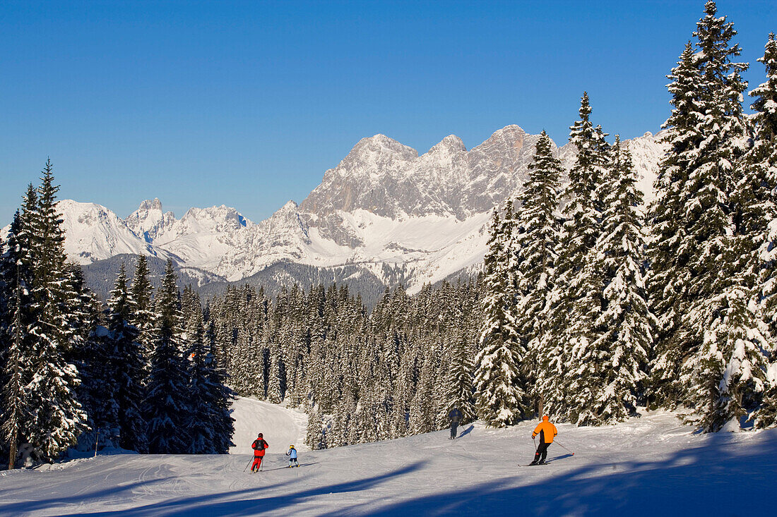 Skiers on slope, summit of the Dachsteinregion at horizon, Schladming, Ski Amade, Styria, Austria