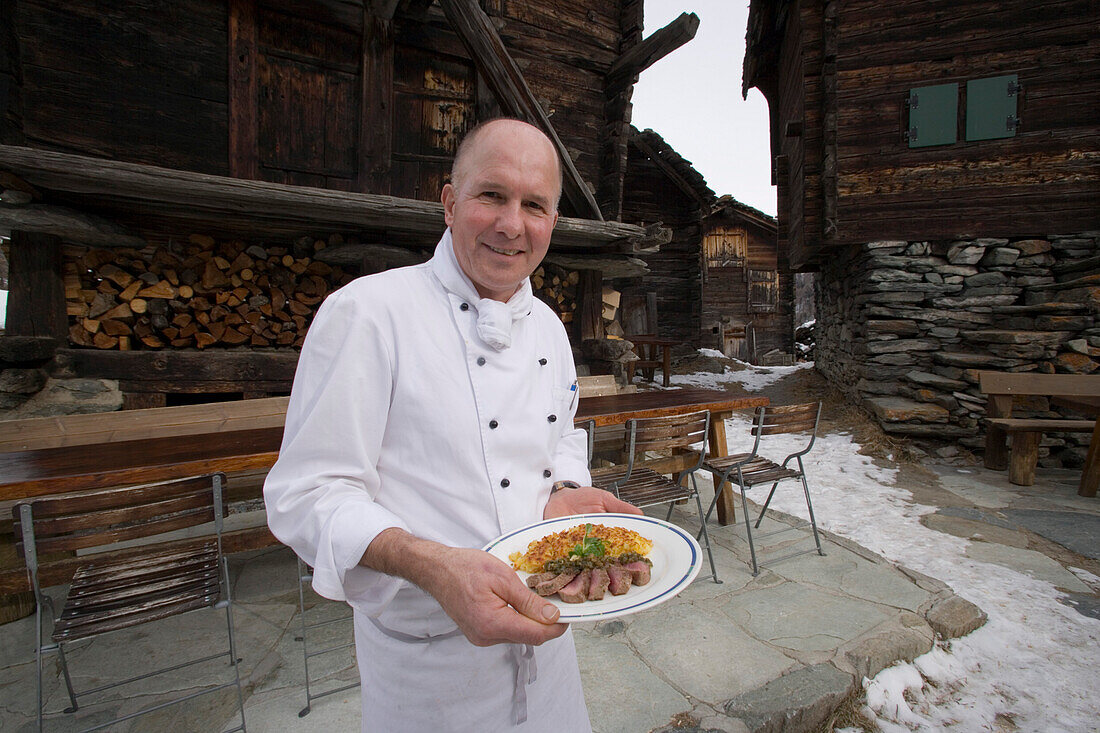 Cook holding plate, Restaurant Zum See, Zermatt, Wallis, Switzerland