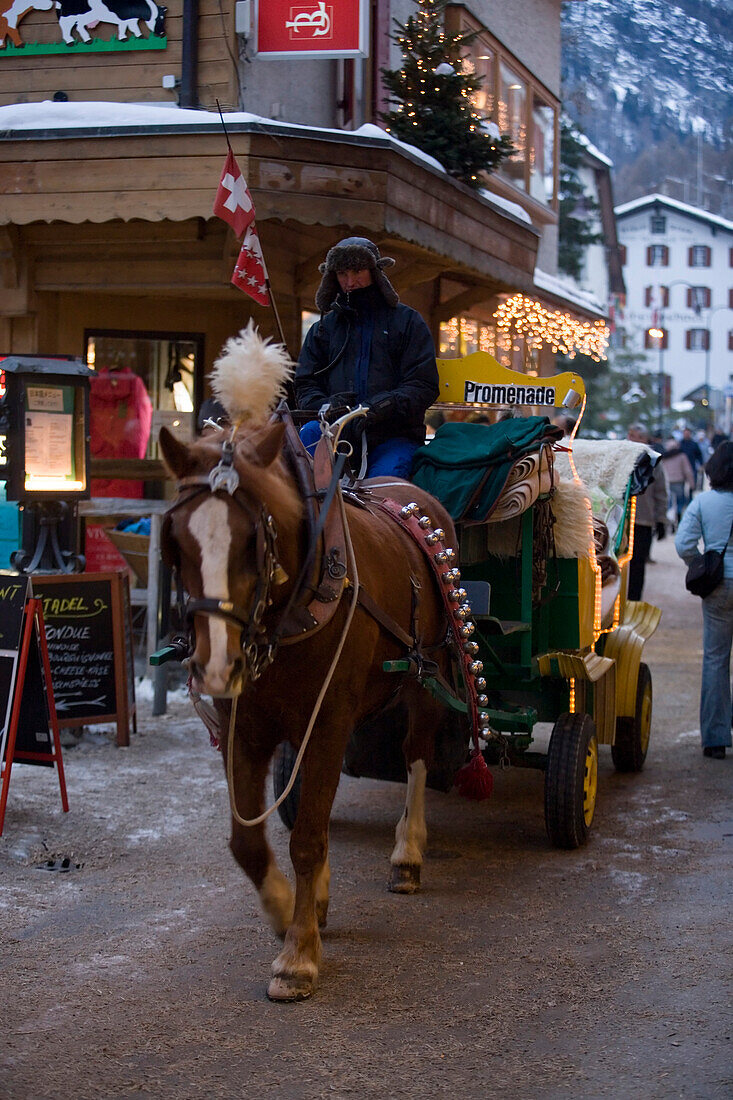 Carriage passing shopping street Bahnhofstrasse, Zermatt, Valais, Switzerland