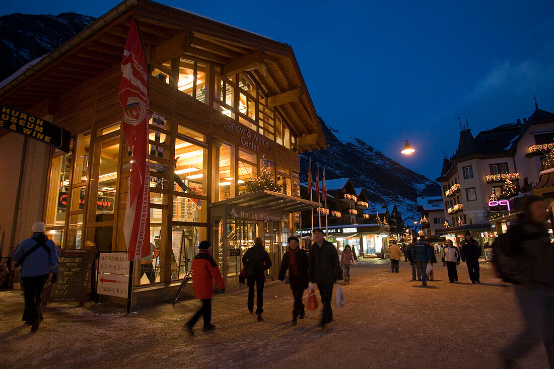 People walking over the shopping street Bahnhofstrasse in the late evening, Zermatt, Valais, Switzerland