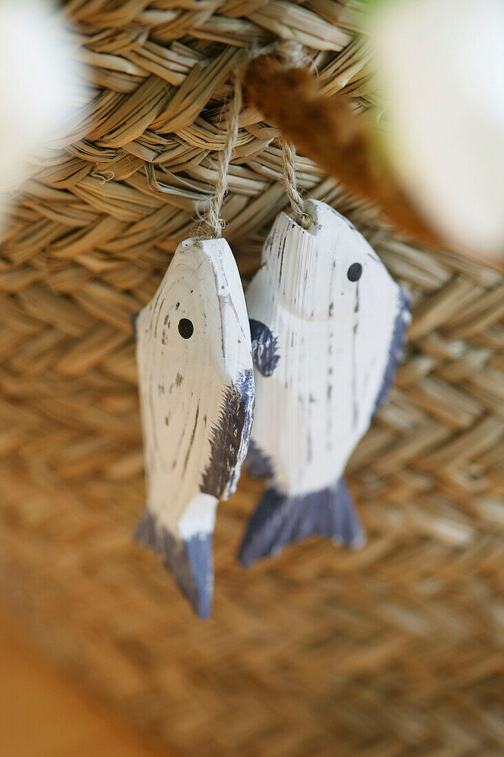 Wooden fishes hanging on straw basket